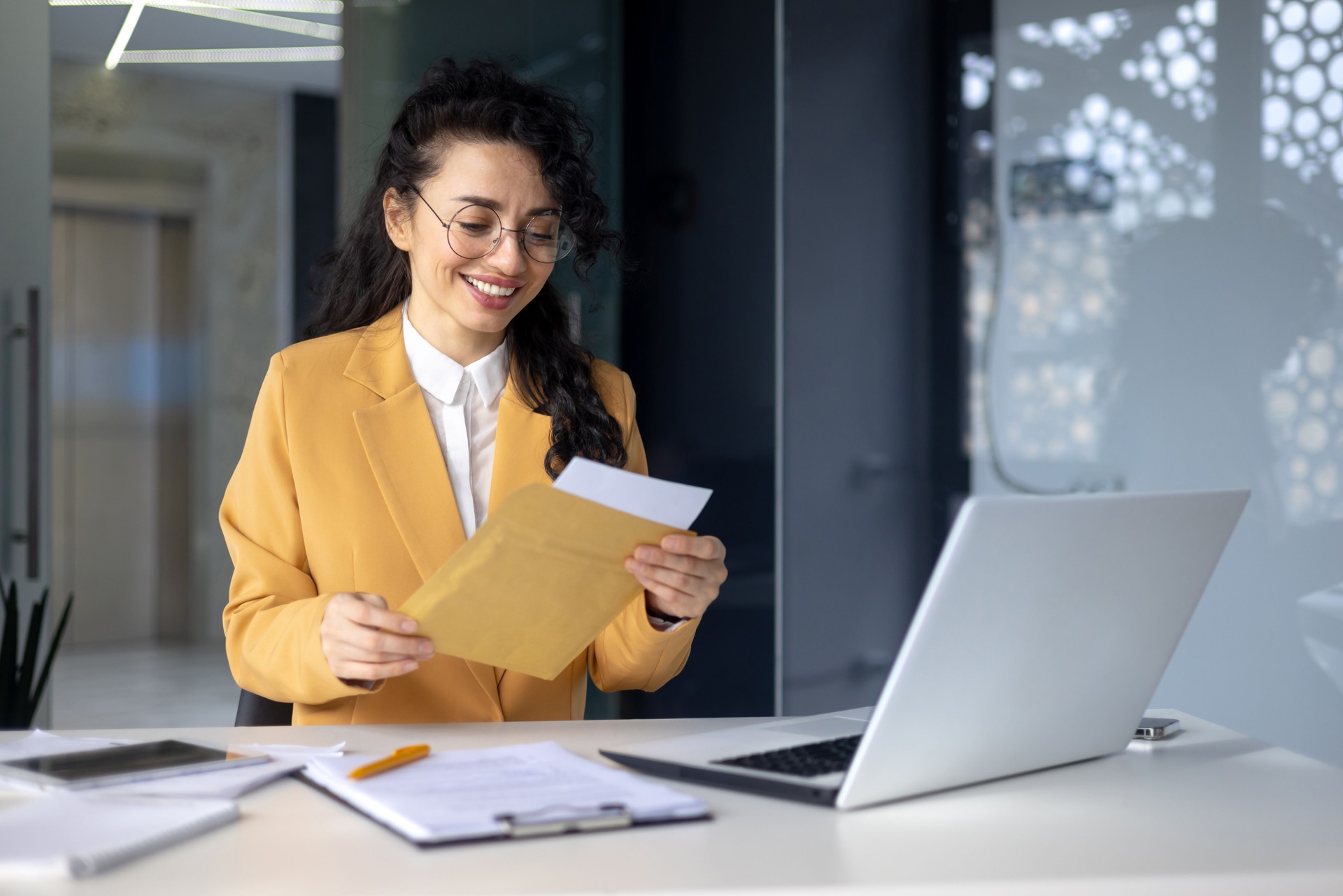 Exitosa mujer hispana dentro de la oficina en el trabajo empresaria recibió una notificación de sobre postal con buenas noticias, trabajadora celebrando victoria y buenos resultados en el lugar de trabajo